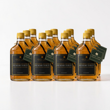 Load image into Gallery viewer, A 12 pack case of bottle of Arbor and Field Black Label Bourbon-Infused bottle aged Shagbark Hickory Syrup with black and gold foil label. A piece if bourbon-infused shagbark hickory bark can be seen inside of the bottle. A green gift tag hangs from the neck of the bottle on a gold string. Clean white background, premium look and feel.
