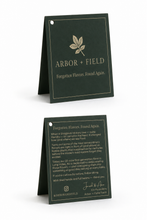Load image into Gallery viewer, Folded hangtag Front and Back. Dark green with cream text and cream leaf logo.