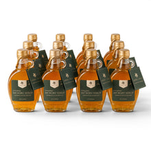 Load image into Gallery viewer, 12 bottles of Shagbark Hickory Syrup 8 oz flasks with green and cream Arbor and Field Label on the front, a gold wax dipped cap and dark green gift tag hanging around the neck of the bottle from a gold string. Clean white background, premium look and feel.