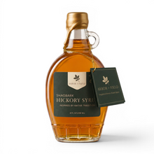 Load image into Gallery viewer, Shagbark Hickory Syrup 8 oz flask bottle with green and cream Arbor and Field Label on the front, a gold wax dipped cap and dark green gift tag hanging around the neck of the bottle  from a gold string. Clean white background, premium look and feel. 
